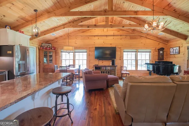 a living room with furniture a wooden floor and a chandelier
