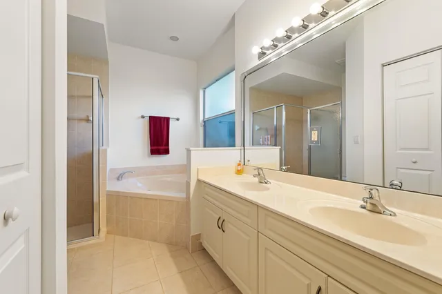 a spacious bathroom with a tub double sink and mirror