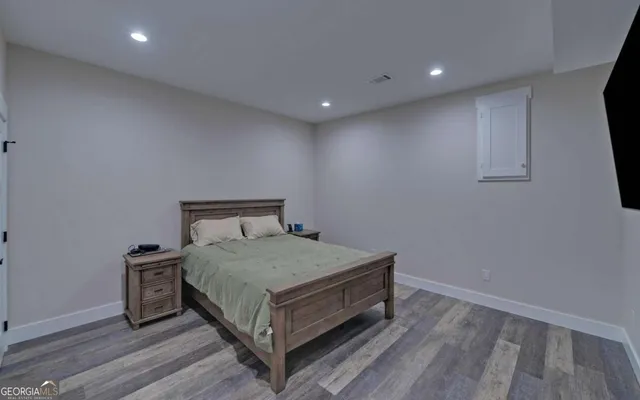 a bedroom with a bed a dresser and a chandelier
