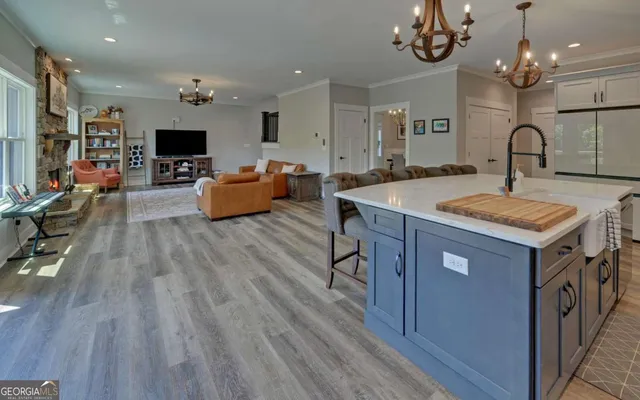 a large kitchen with stainless steel appliances a large center island attached withe living room