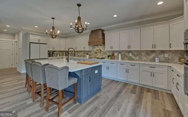 a kitchen with a sink stove cabinets and wooden floor