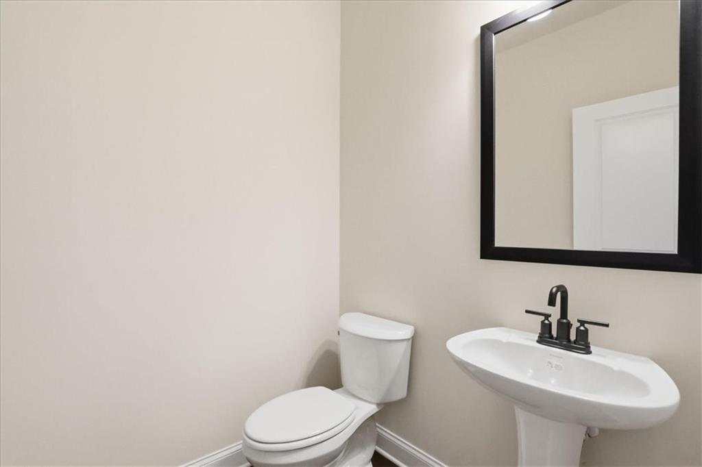 2013 Seclusion Trail Monroe, GA 30656 - Photo 28 of 63 a bathroom with a sink a mirror and a toilet