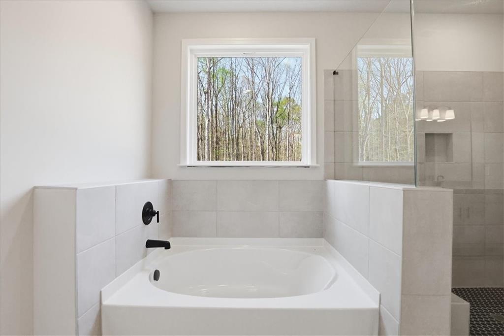 2013 Seclusion Trail Monroe, GA 30656 - Photo 37 of 63 a white bath tub sitting in a bathroom next to a window