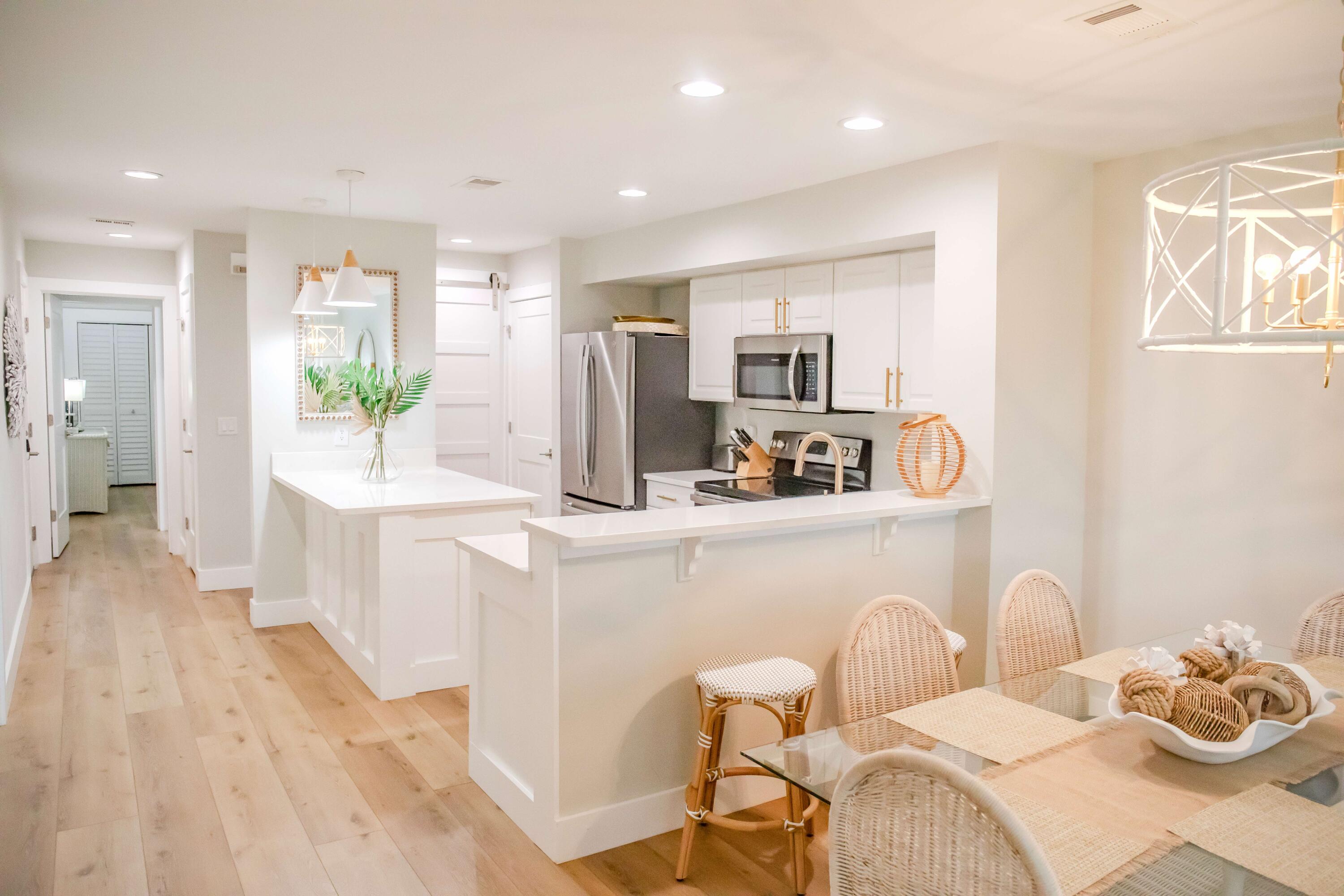 822 Harbour Point Drive, Unit 822 Miramar Beach, FL 32550 - Photo 3 of 41 a kitchen with kitchen island a stove a sink a refrigerator dining table and chairs