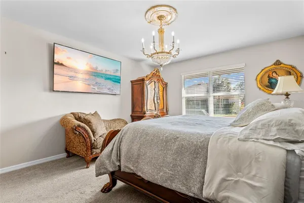 a bedroom with bed and a chandelier