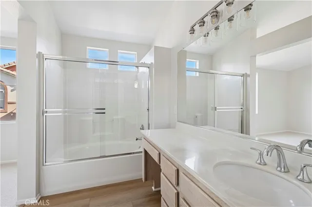 a bathroom with a tub sink vanity and mirror