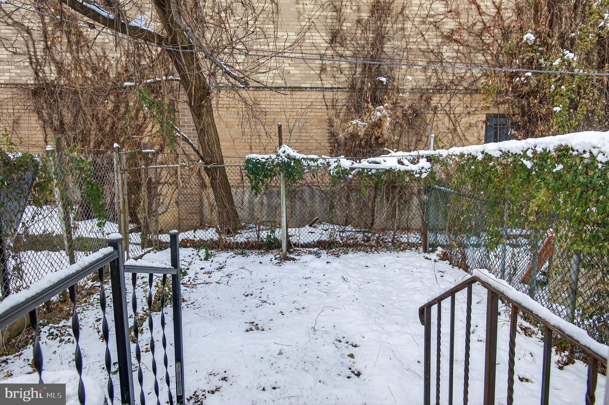 39 Carroll Street Trenton, NJ 08608 - Photo 27 of 27 a backyard of a house with large trees and wooden fence