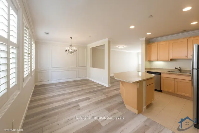 a kitchen with a refrigerator and white cabinets