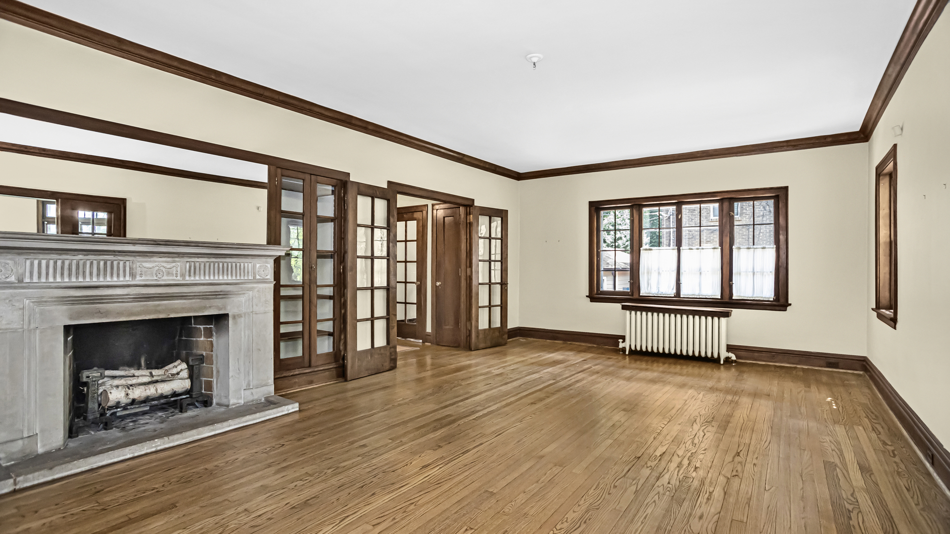 719 Milburn Street Evanston, IL 60201 - Photo 6 of 35 a view of an empty room with exposed radiator and fireplace