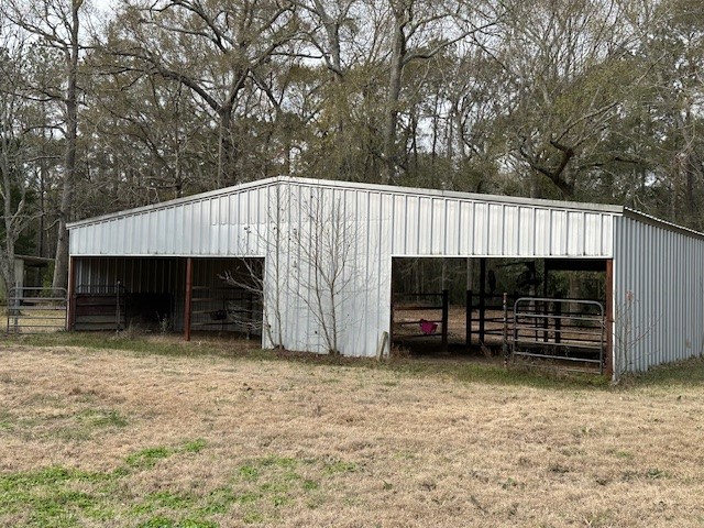 24331 Farm To Market Road 2090 Splendora, TX 77372 - Photo 23 of 38 a view of a house with a garage and a car parked in a yard