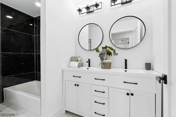a bathroom with a bathtub a sink and a mirror
