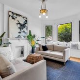 a living room with furniture potted plant and a large window
