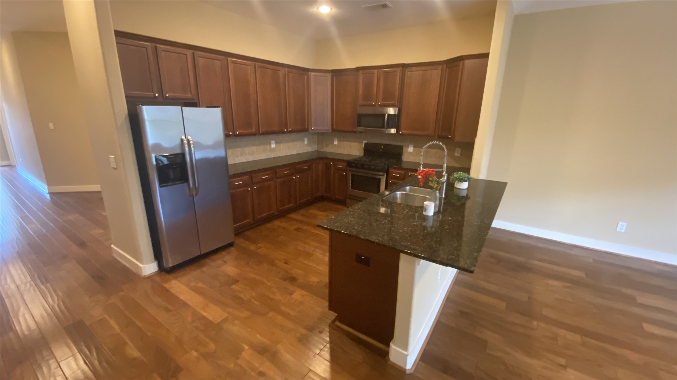 6057 Yale Street Houston, TX 77076 - Photo 17 of 49 a kitchen with stainless steel appliances granite countertop a refrigerator a sink a stove a microwave and wooden floors