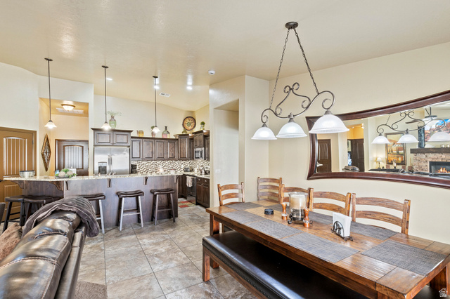 210 Talon Court Ivins, UT 84738 - Photo 18 of 60 Dining room with a high ceiling, a stone fireplace, and light tile patterned flooring