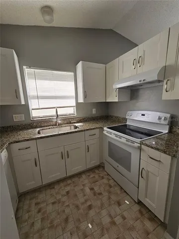 a kitchen with cabinets appliances and a window