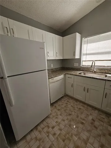 a white refrigerator freezer sitting inside of a kitchen