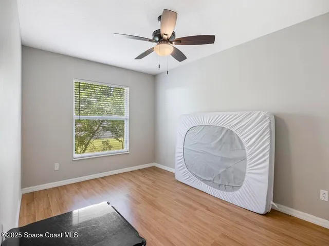 a spacious bedroom with a bed and a large window