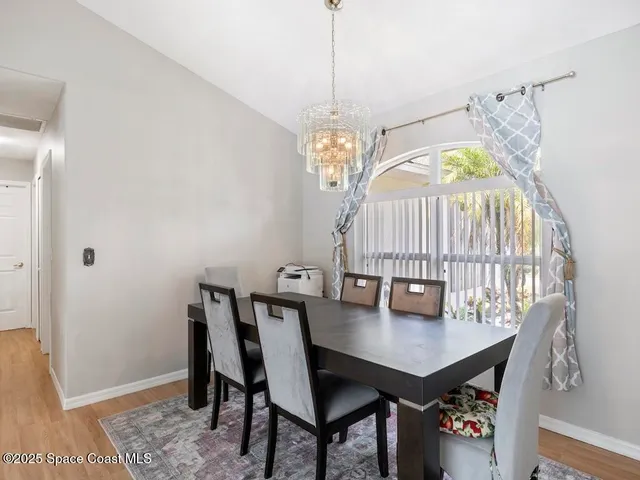 a view of a room with wooden floor table and chairs