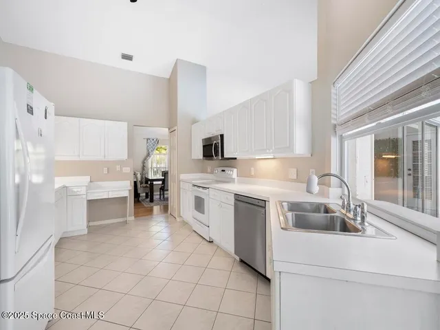 a view of a livingroom with wooden floor and a ceiling fan