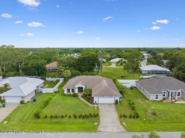a front view of a house with a yard and potted plants