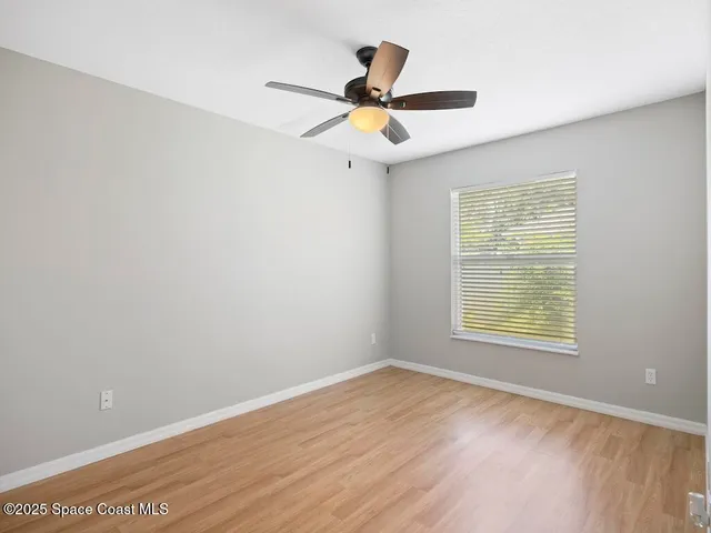 a view of a big room with wooden floor and a ceiling fan