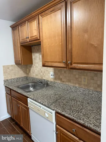 a kitchen with granite countertop cabinets washer and dryer