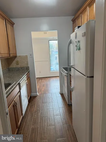 a kitchen with wooden floors and appliances