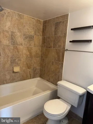 a white toilet and tub sitting next to a bathroom sink