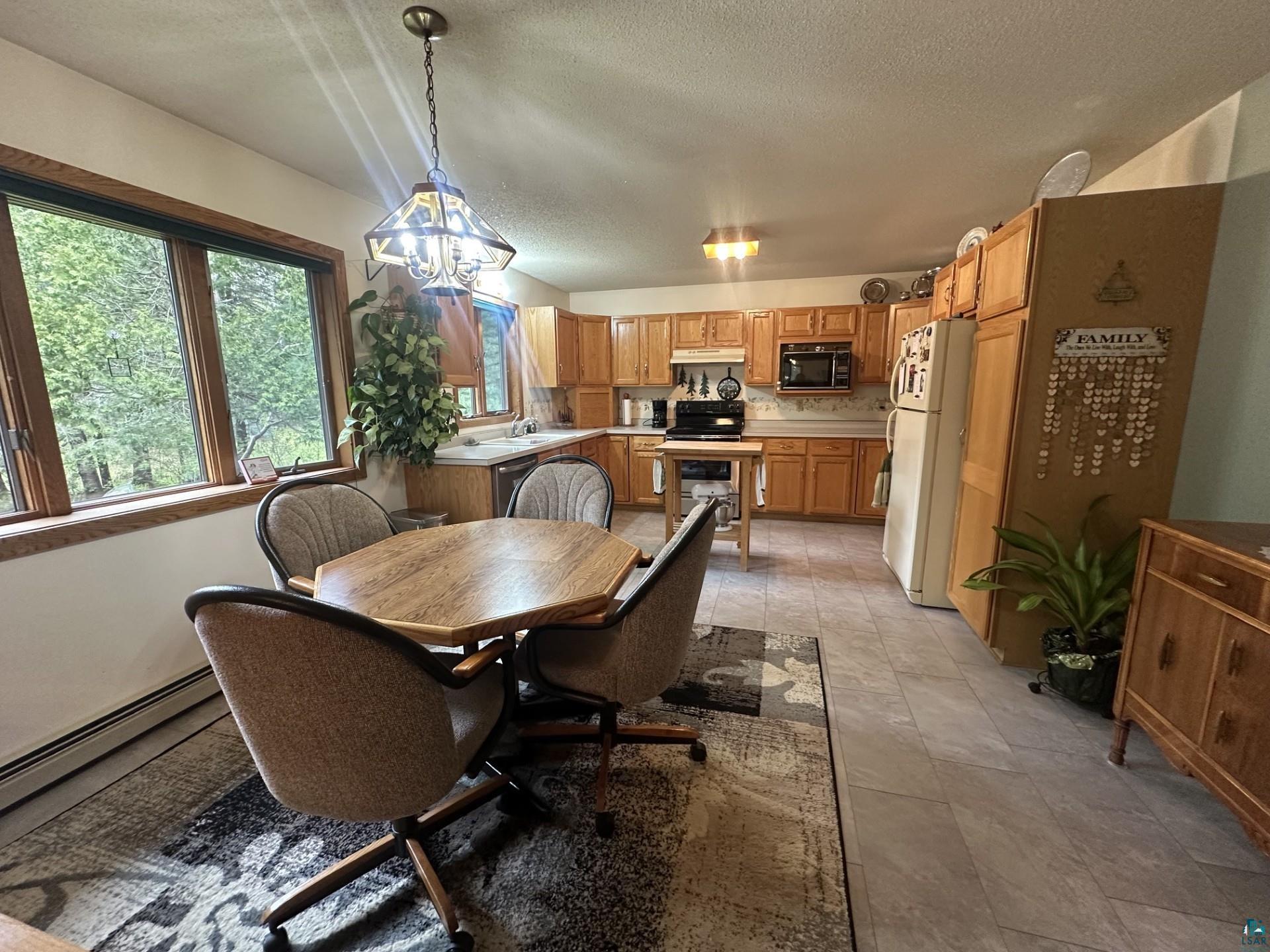 81 Hautaluoma Road Esko, MN 55733 - Photo 11 of 43 Kitchen featuring wood cabinetry, light-toned countertops, and a tiled backsplash