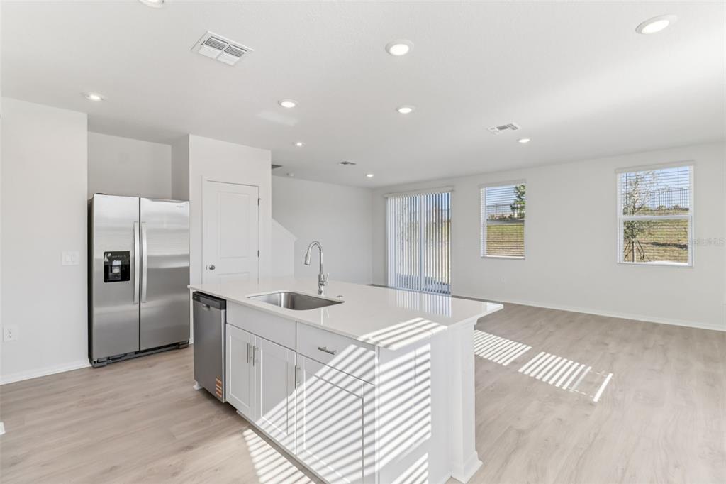 721 Spartina Street Lady Lake, FL 32159 - Photo 12 of 32 a kitchen with stainless steel appliances granite countertop a sink and a refrigerator