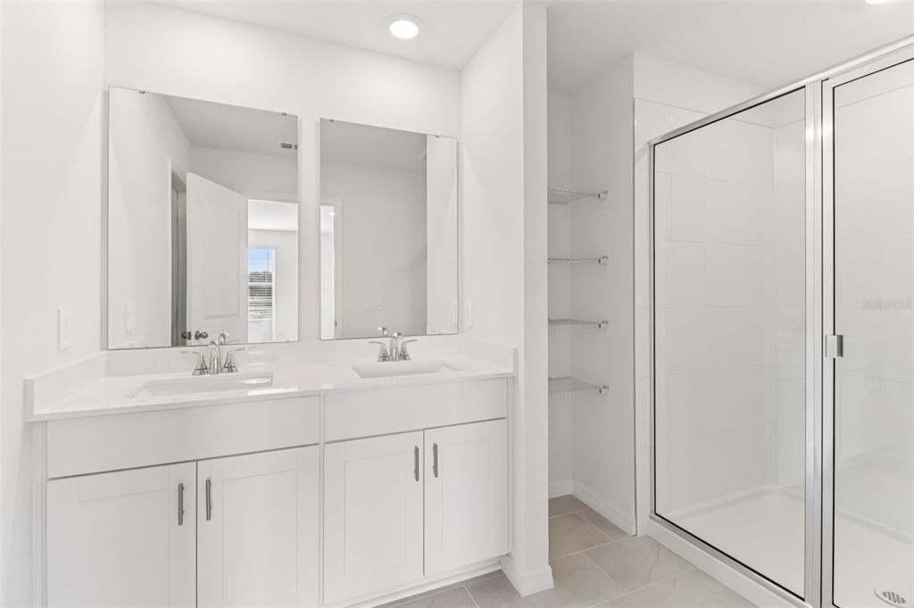 721 Spartina Street Lady Lake, FL 32159 - Photo 28 of 32 a bathroom with a double vanity sink mirror and shower