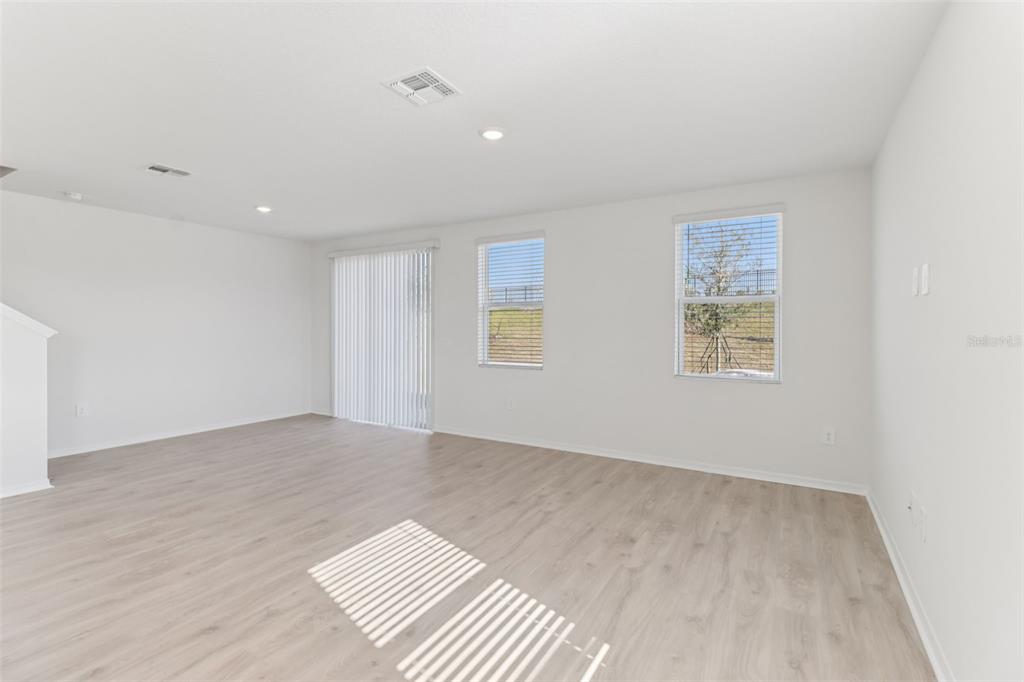 721 Spartina Street Lady Lake, FL 32159 - Photo 6 of 32 an empty room with wooden floor and windows