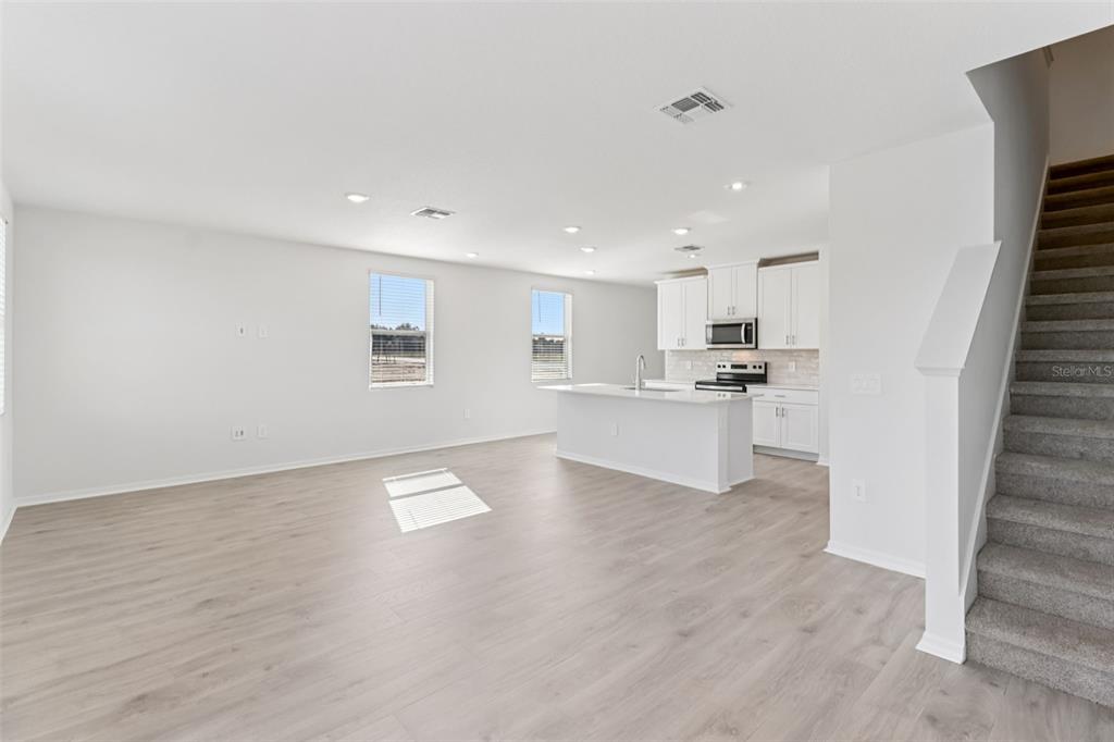 721 Spartina Street Lady Lake, FL 32159 - Photo 8 of 32 a view of a kitchen with wooden floor and electronic appliances