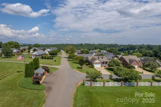 an aerial view of a house with a garden and lake view