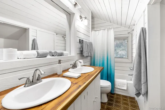 a bathroom with a granite countertop sink toilet a mirror and shower