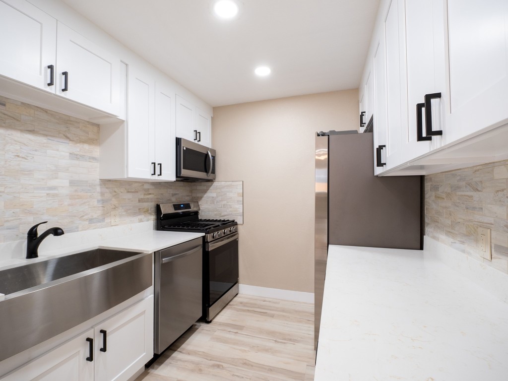 8314 Bowling Green Drive, Unit B Austin, TX 78757 - Photo 21 of 22 Kitchen with decorative backsplash, white cabinets, stainless steel appliances, recessed lighting, and light wood-style floors
