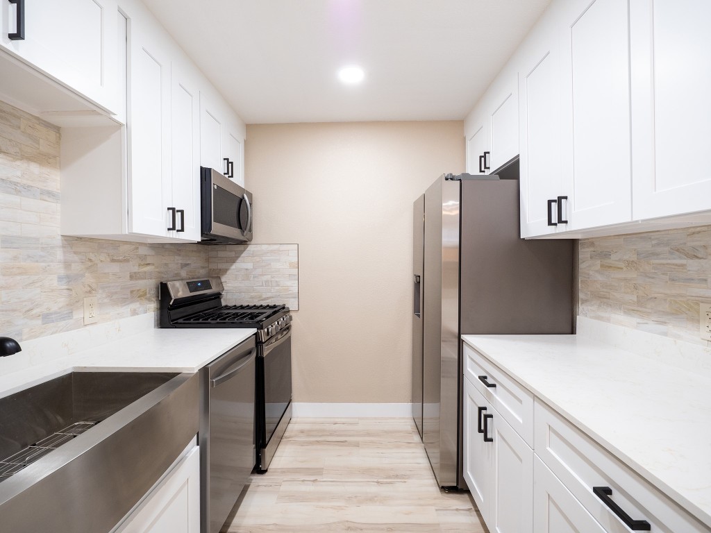 8314 Bowling Green Drive, Unit B Austin, TX 78757 - Photo 22 of 22 Kitchen featuring tasteful backsplash, white cabinets, appliances with stainless steel finishes, light stone countertops, and recessed lighting