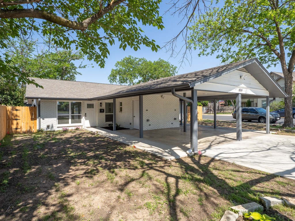8314 Bowling Green Drive, Unit B Austin, TX 78757 - Photo 3 of 22 Back of house featuring brick siding, a carport, roof with shingles, and concrete driveway