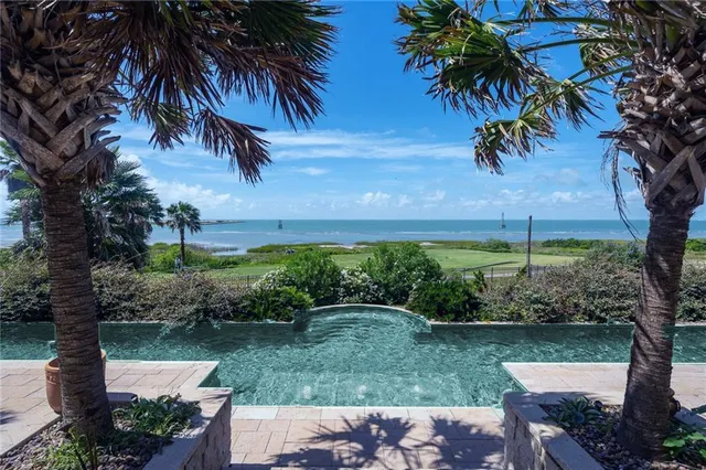 a row of palm trees in front of a building