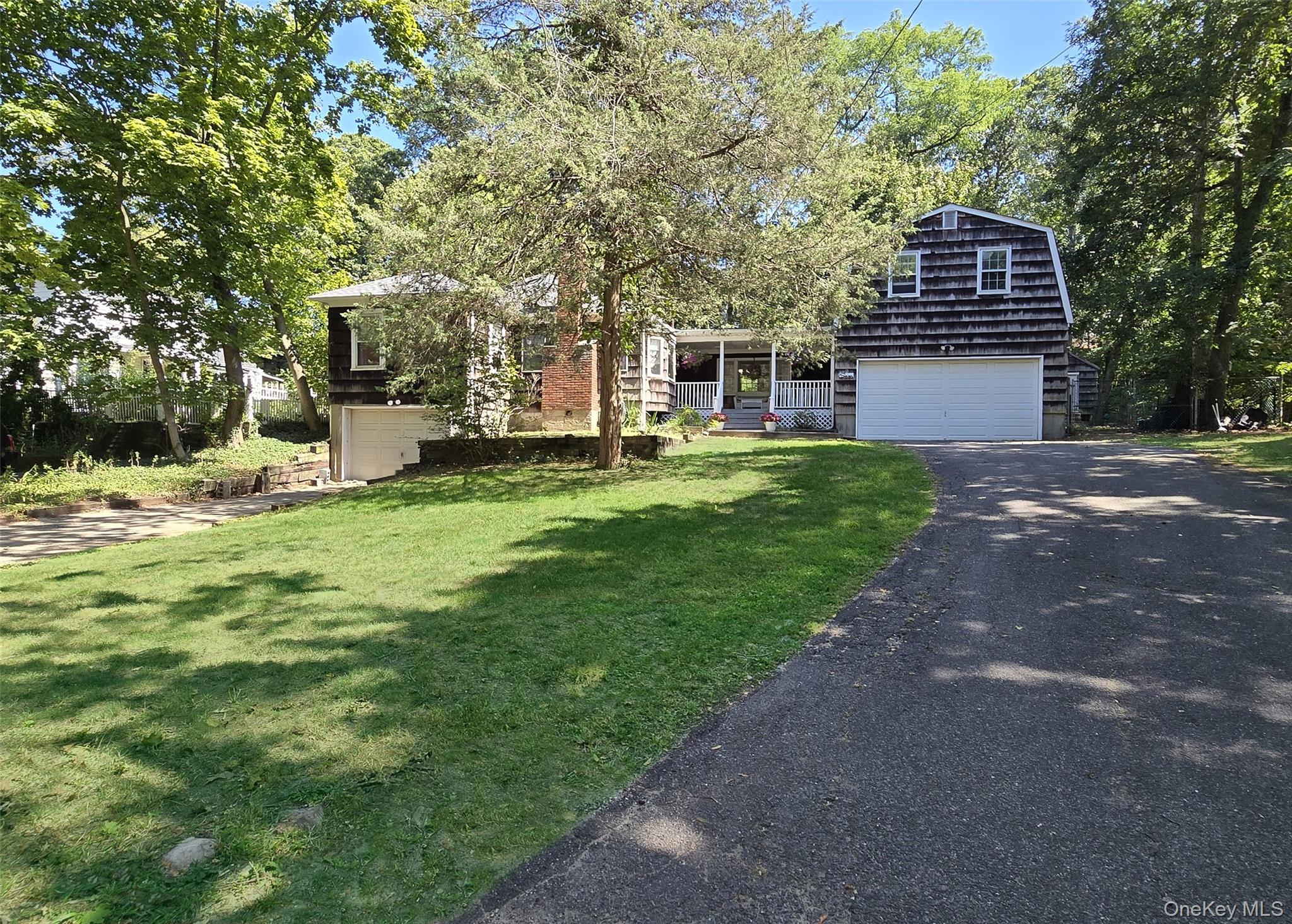 7 Woodhull Landing Road Sound Beach, NY 11789 - Photo 1 of 1 a front view of a house with a garden and trees