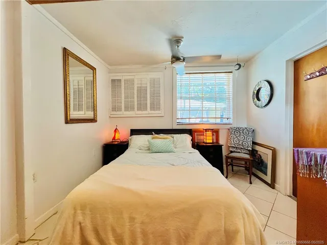 a bedroom with a bed and a large window with chair