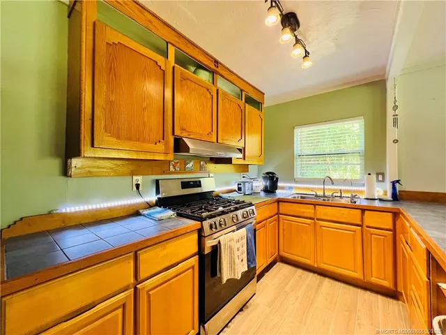 a kitchen with stainless steel appliances granite countertop a sink a stove and a refrigerator
