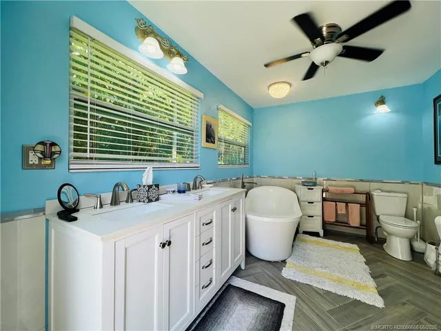a bathroom with a double vanity sink a mirror and a bathtub