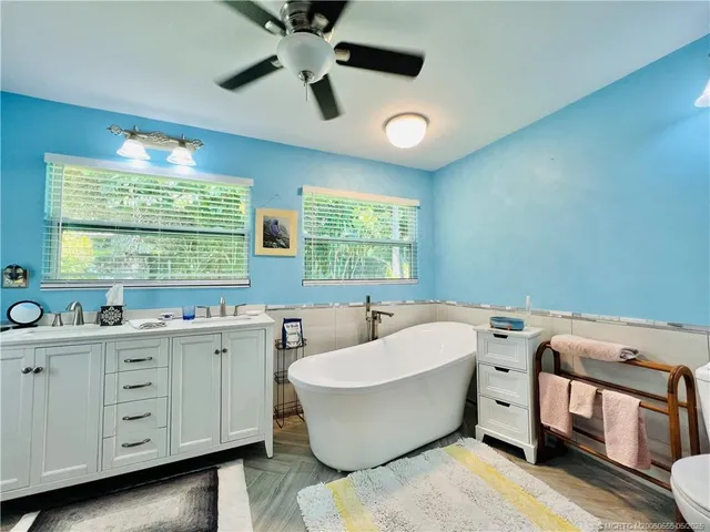 a bathroom with a double vanity sink a mirror and a bathtub