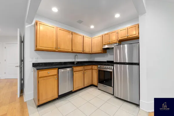 a kitchen with stainless steel appliances granite countertop a refrigerator sink and cabinets