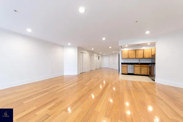 a view of empty room with wooden floor