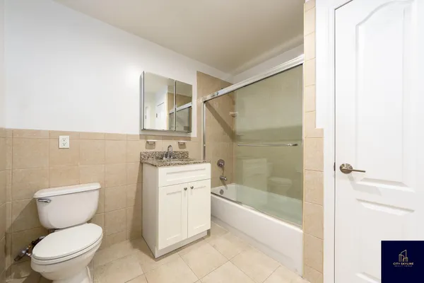 a bathroom with a granite countertop toilet a sink and bathtub