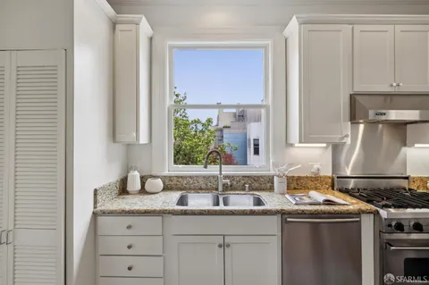 a kitchen with stainless steel appliances granite countertop a sink stove and cabinets