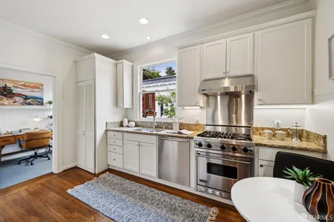 a kitchen with stainless steel appliances granite countertop a stove a sink and a refrigerator