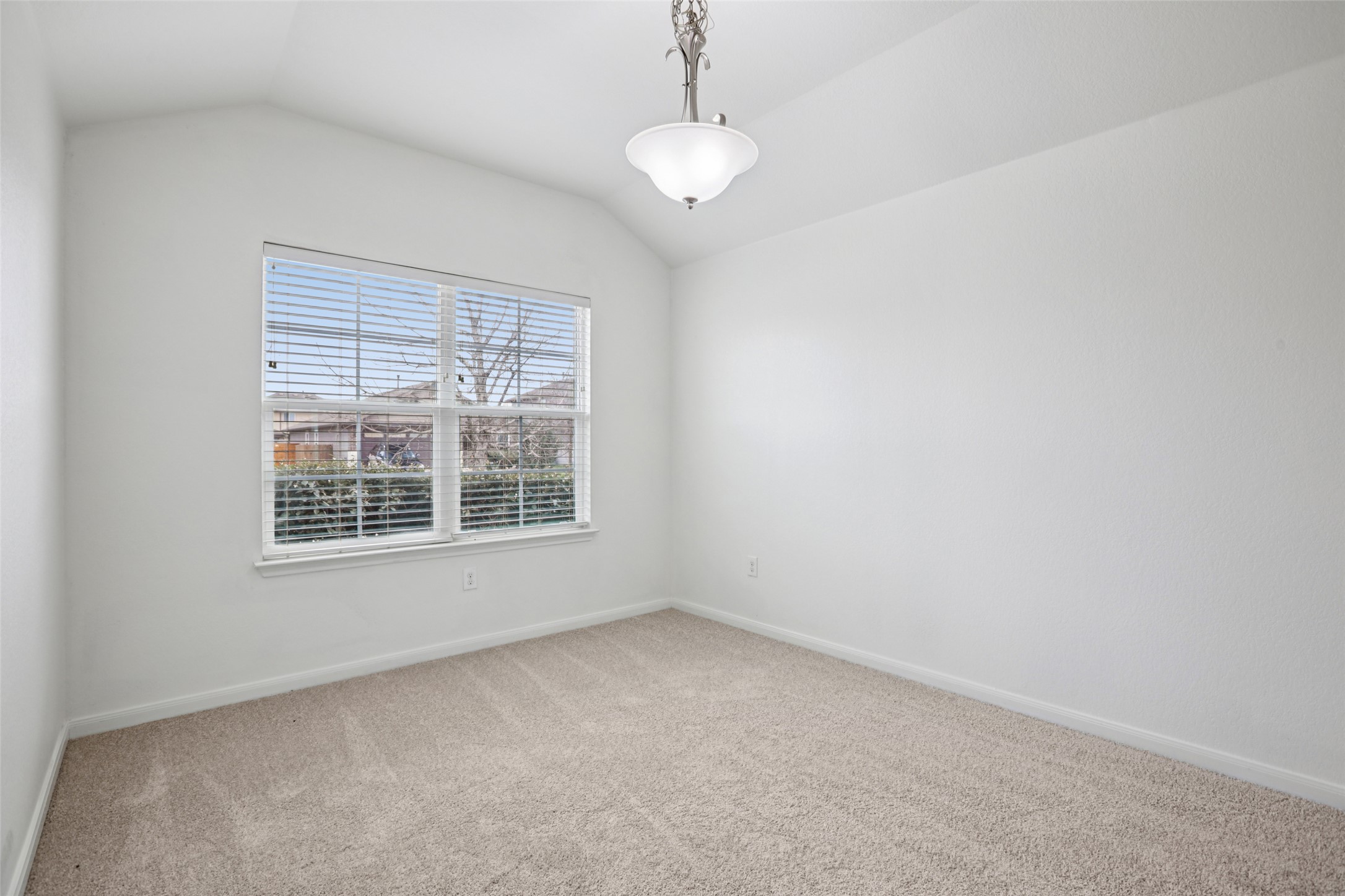 221 Alpha Kyle, TX 78640 - Photo 14 of 37 Spare room featuring light colored carpet and vaulted ceiling